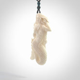 Hand carved large natural bone mermaid pendant. Hand made from real bone. Art to wear. Provided with an adjustable length black cord and packaged in a woven kete pouch. Bone mermaid necklace.